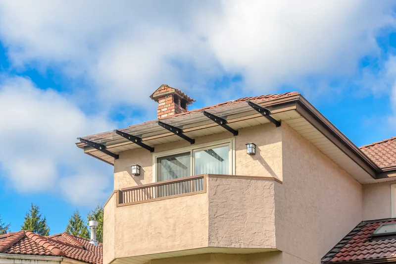 Cream stucco building with a balcony and a terracotta tile roof