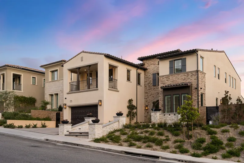 Row of stucco and stone homes above desert scrub at sunrise