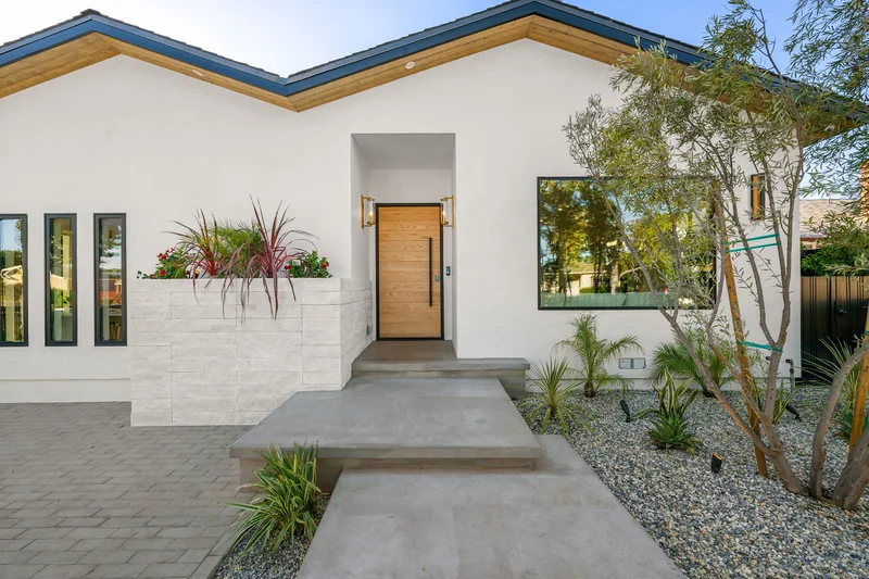 Low desert-modern stucco entry with gravel beds and drought-tolerant planting