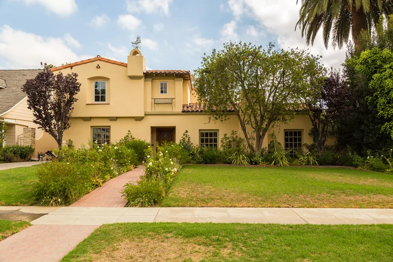 Two-storey Mediterranean-style stucco house with a tiled roofline