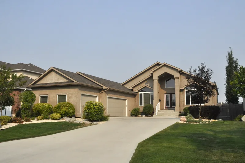 Single-storey stucco ranch with a wide driveway and a low-pitched roof