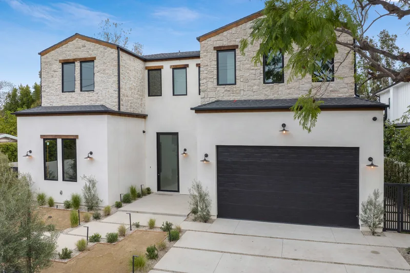 Light stucco home fronted by a gravel xeriscape and a paved drive